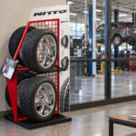 Oto bakım merkezinin bekleme alanında kırmızı metal otomobil lastiği standı.